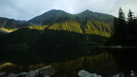 Timelaps of clouds passing over the lake among the mountains 4k HDR H264