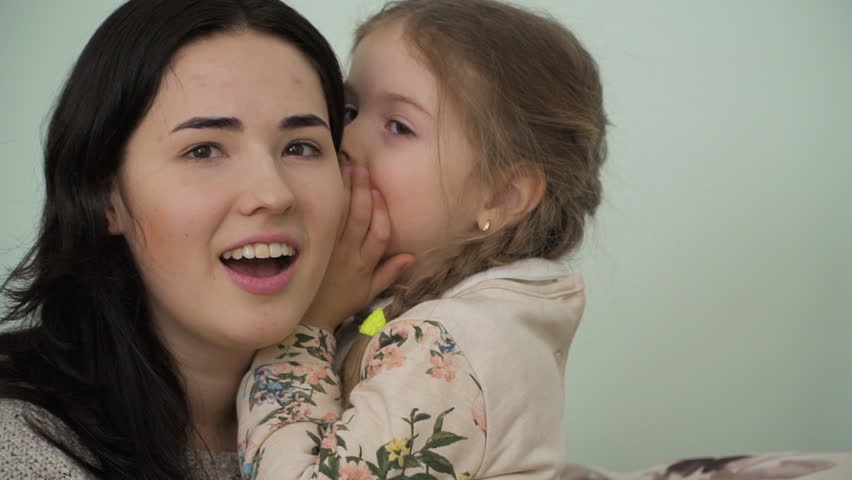 Mother and little daughter trust their secrets to each other