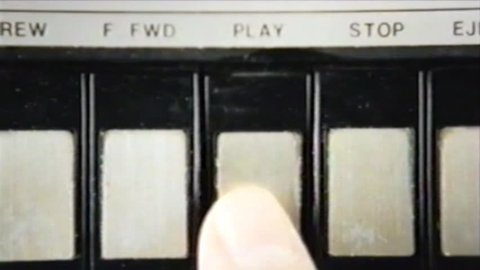 VHS tape capture: pressing play and stop, multiple times, on a vintage player; inserting an audio cassette. Close-up shot.