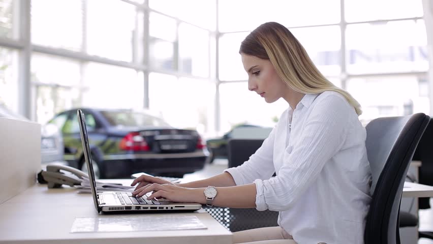 Saleswoman In Car Shop Working On Laptop Royalty-Free Stock Footage #1009652504