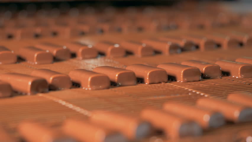 Close-up view on production line with chocolate candy bars.