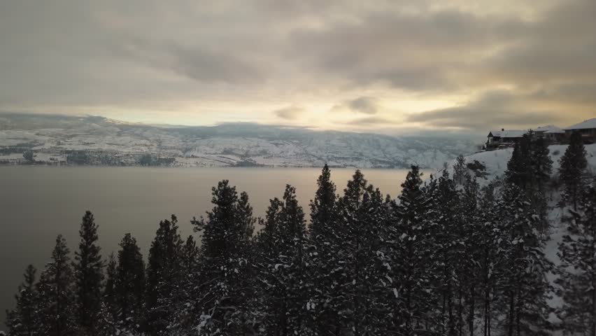 Aerial view of the luxury homes on top of a hill during a vibrant winter sunset. Taken in Kelowna, British Columbia, Canada.
