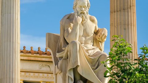 Statue of the great Greek philosopher Socrates on a marble chair, background of columns and sky, time lapse.