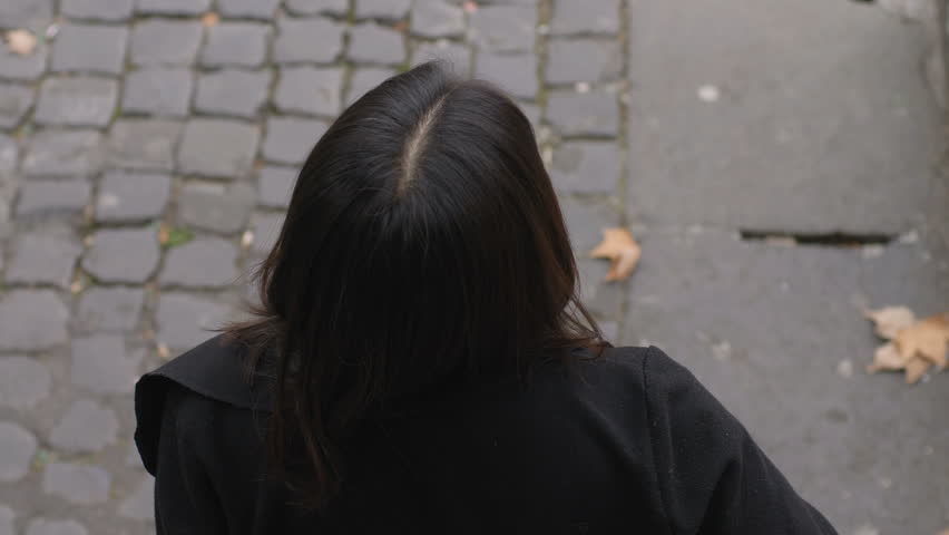 Happy Chinese woman in the street raises her head and smiles at the camera