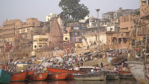 Panning shot of colourful boats moored by a ghat