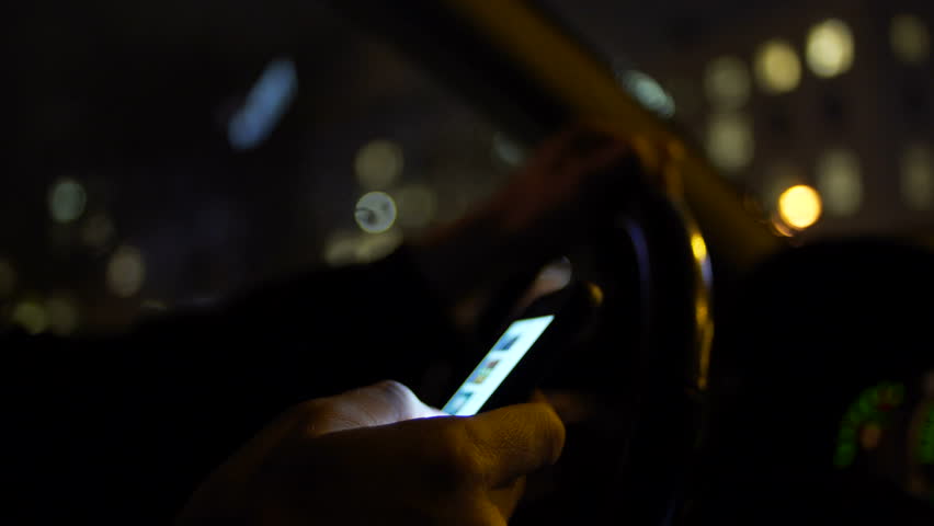Using smartphone while driving at night in the city Royalty-Free Stock Footage #1009661222