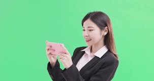businesswoman play mobile game on the green background