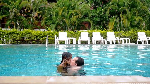 Young couple kissing in the swimming pool on their vacation. slow motion. 1920x1080