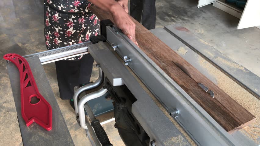 Construction worker using table saw for cutting wood plank. Daetails of construction, renovation works.