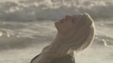 blonde woman in dress lies on the beach. Sexy girl sunbathing