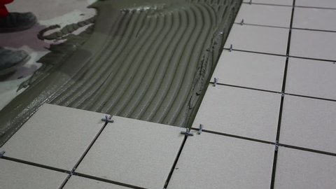  Master puts and glues tile floor tiles. Laying of tile adhesive.