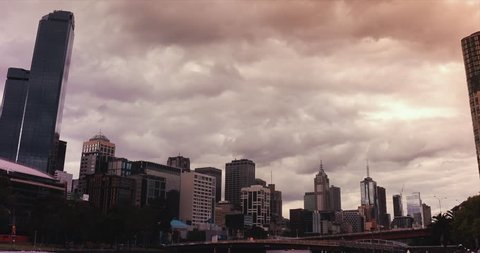Cinematic time lapse of skyscraper in Melbourne Centre Business District during sunset with gloomy cloud and sky changing color.All logotype removed.Camera pan from left to right.