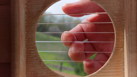 Playing acoustic guitar viewed from the inside, weird perspective