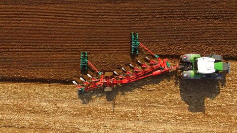 Aerial: Tractor plowing a agricultural field - aerial view - Tractor cultivating arable land for seeding crops, aerial view - 4K UHD - germany