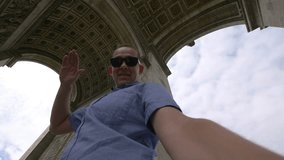 Professional video of man taking selfie with a view on Arc de Triomphe in Paris in 4k slow motion 60fps