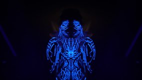Psychedelic movement of the girl's body with body art drawing on stage in the UV light