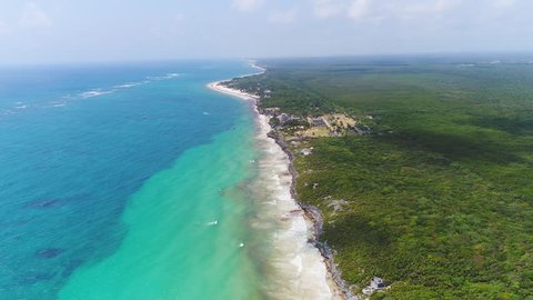 Aerial view of ruins in coastal Mayan city of Tulum, lush jungle, beach and crystal clear waters of Caribbean Sea - Yucatan Peninsula, Mexico from above, 4k UHD