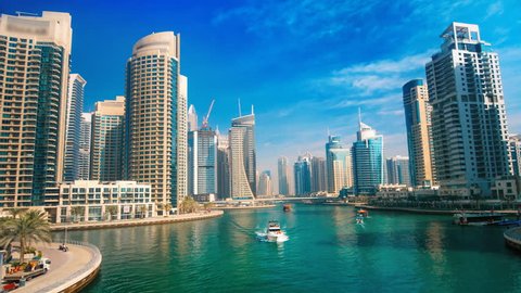 Dubai Marina under blue sky, with boats and skyline, hyperlapse footage