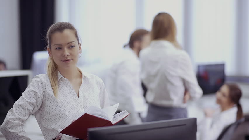 Beautiful businesswoman smiles and flirts with her colleague in the office