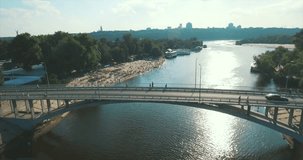 Aerial footage of the beach in Kiev-Ukraine. Flight on the embankment of the hydropark, a large number of people sunbathe under the sun. Summer sunny day, the beach many people rest and bathe. 