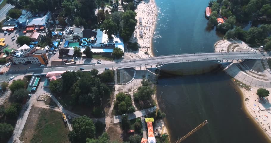 Aerial footage of the beach in Kiev-Ukraine. Flight on the embankment of the hydropark, a large number of people sunbathe under the sun. Summer sunny day, the beach many people rest and bathe. 