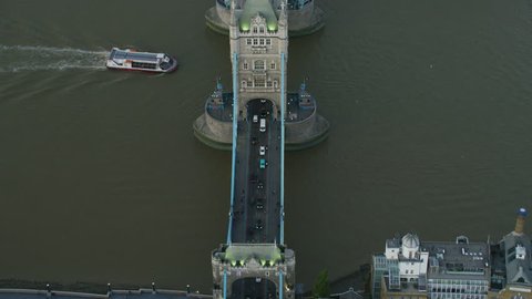 Aerial sunset view commuter vehicles crossing River Thames and passenger ferry travelling under Tower Bridge London England UK RED WEAPON
