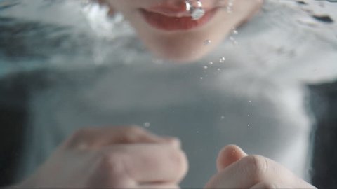 slow motion woman cleaning her face under water
