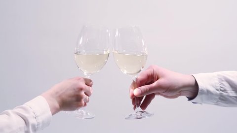 white wine toast, cheers and clinking wine glasses on white background