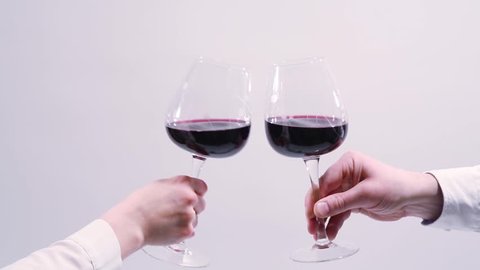 red wine toast, cheers and clinking wine glasses on white background