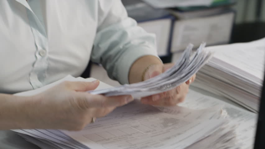 Hands shift a stack of documents | Shutterstock HD Video #1009763894