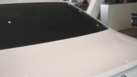 modern car salon, view of white car exterior, smooth camera movement
