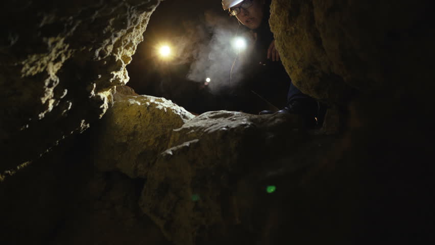 The speleologist finds the dangerous passage in the cave and starts to go. 4K