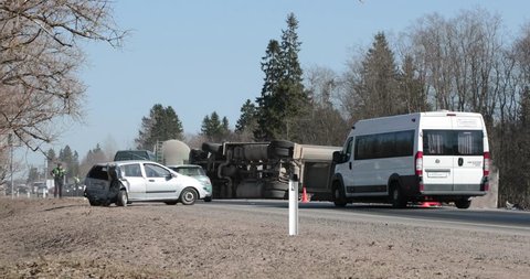 BEGUNITSY, LENINGRAD REGION, VOLOSOVO DISTRICT, RUSSIA - APRIL 13, 2018 Road traffic accident. Truck with sand rolled onto his side, broken car.