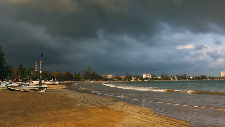 Seashore landscape. Fishing Boats in Sri Lanka during sea storm under heavy clouds as seen from the beach. Sri Lankan Fishing. Beautiful stormy Sea view, seashore. Beach landscape (Beachscape). 