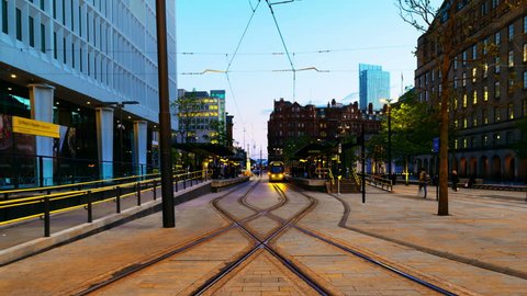 Manchester, England. Light rail yellow tram in city center of Manchester, UK in the evening. Time-lapse from day to night with illumination