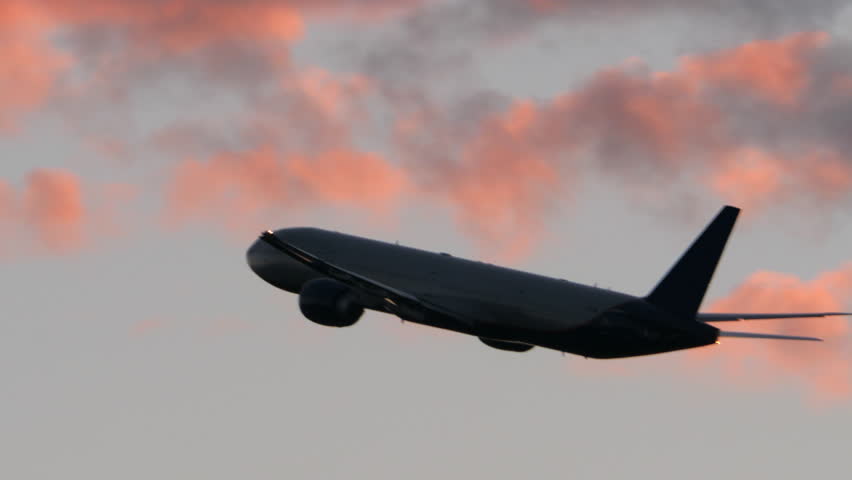 Airplane flying and gaining height in evening cloudy sky