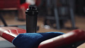 Close up hand man take bottle resting in the gym look at camera face body workout athlete exercise training sport young male bodybuilding handsome portrait slow motion