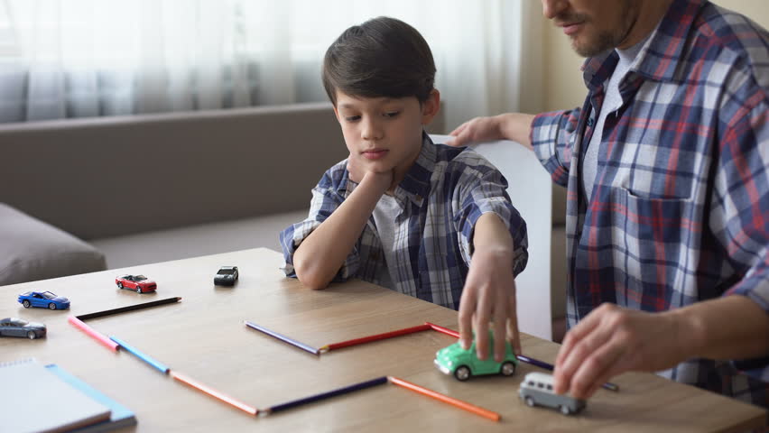 Kind father playing toy cars with his little son, parental care, togetherness
