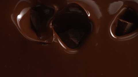 Chocolate falling in chocolate sauce. Slow motion.