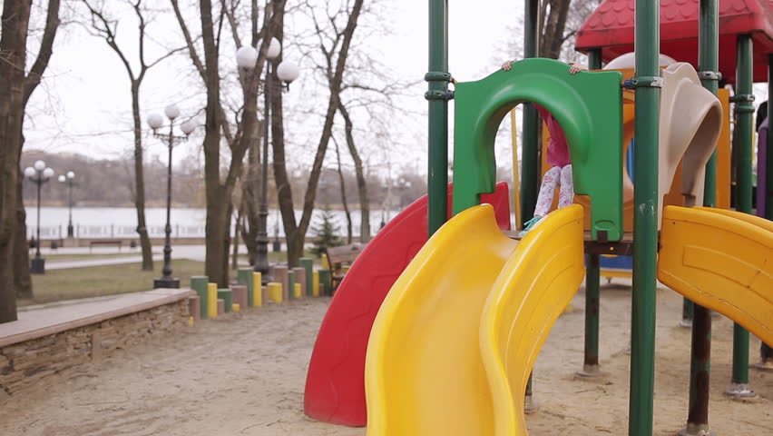 little girl in spring Park with rolls of bright-colored slides