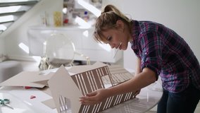 Student of Interior Design school doing homework, reviewing and preparing house model. Young woman at work as architect in professional studio - Powered by Shutterstock - Get 15% off with code: PIKWIZARD15