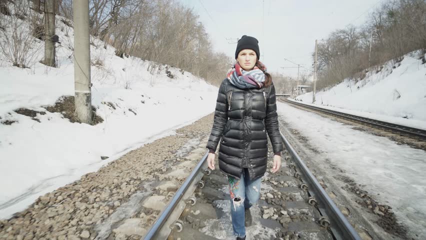 Young girl walks on the railway.