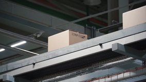 Automation - Cardboard boxes on conveyor belt in factory. Clip. Boxes moving on the conveyor at the factory