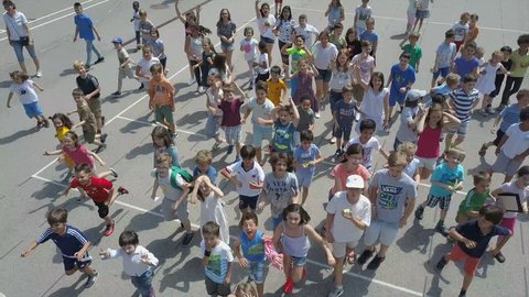 VIENNA AUSTRIA - CIRCA SEPTEMBER 2017: Crowd of Happy children in school playground of French high school running towards a drone