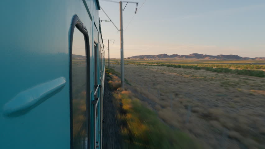 Train rolling on tracks in Kazakhstan at sunset Royalty-Free Stock Footage #1009855097