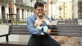 Young father and child sitting on bench on home yard