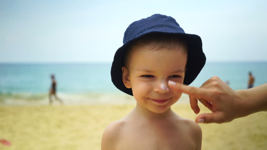 Mom masks her son with sunblock cream | Shutterstock HD Video #1009859462