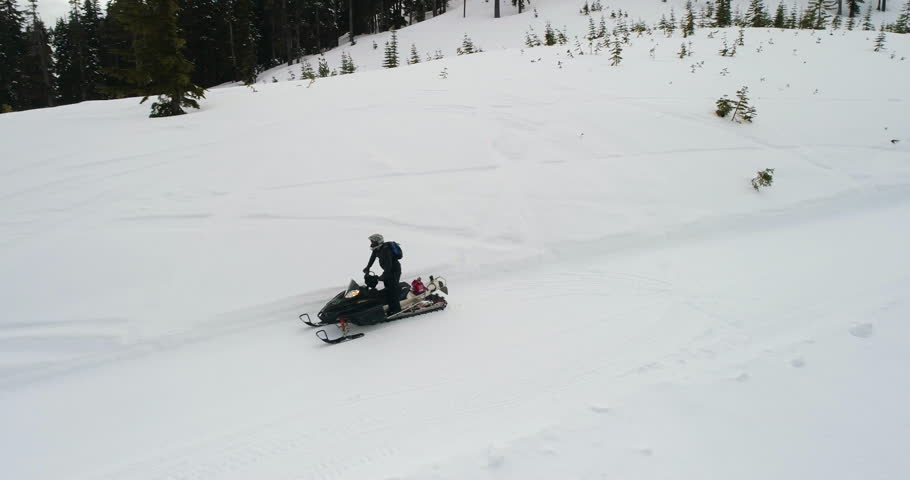 Snowmobile Winter Man Riding Snowmachine Down Mountain Cattrack Aerial View Reveal Nature Background