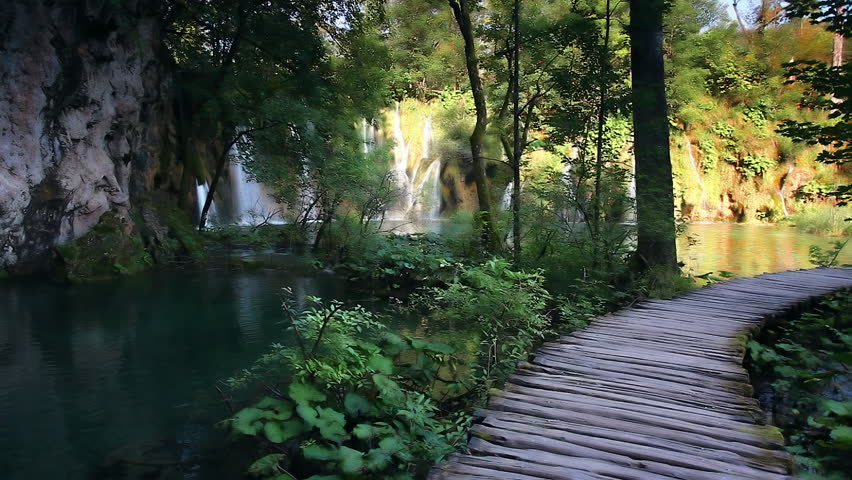 The path wooden boards above the water. Location famous Plitvice Lakes National Park, Croatia, Europe. Scenic footage of popular tourist attraction. Discover the beauty of earth. Full HD 1080p video.