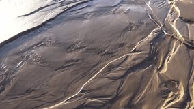 Water flows through the sand leaving beautiful patterns. Video full hd.